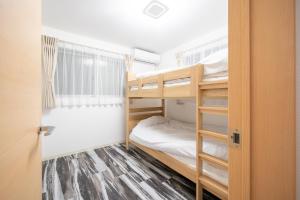 ein kleines Zimmer mit Etagenbetten und einem Fenster in der Unterkunft Familia Kamata 2 in Tokio