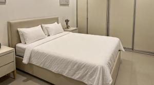 カラチにあるHotel Rest Innのベッドルーム(白いシーツと枕が備わる大きな白いベッド付)