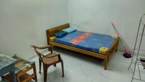 a small bedroom with a bed and a chair at Aadithya homestay in Kovalam