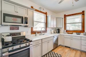 a kitchen with white cabinets and a stove top oven at 3 Mi to Road America Spacious Elkhart Lake Home! in Elkhart Lake