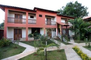 Casa grande de color rojo y blanco con patio en Pousada Recanto, en Pirenópolis