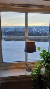 a window with a lamp and a view of the water at Leilighet på Bekkeli, Beito. in Beitostøl +18 photos