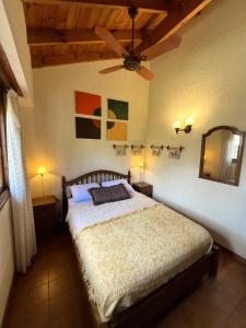 a bedroom with a bed and a ceiling fan at Dúplex Del mar, ideal para descansar en familia - Ayres del Bosque Alojamientos in Pinamar