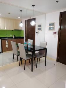 uma sala de jantar com mesa e cadeiras pretas em One Palm Tree Condo em Manilla
