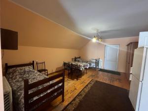 a bedroom with a dining room with a table and a refrigerator at Smerichka in Zagorody
