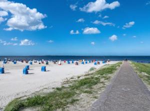 a beach with blue trash cans in the sand at Kleine Austernperle in Dornumersiel
