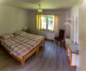 Un dormitorio con una cama y una ventana y una silla. en Ferienwohnung Muschel, en Dornum