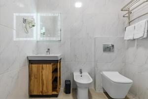 a white bathroom with a toilet and a sink at Green Line in Kyiv +19 photos