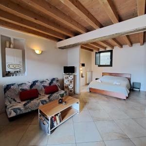 サーレ・マラジーノにあるLAKEly Nestのソファとベッドのあるリビングルーム