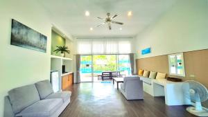 een woonkamer met een bank en een plafondventilator bij บ้านพิม in Pran Buri