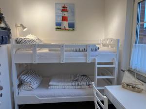two bunk beds in a room with a lighthouse at Ferienhaus Leuchtqualle in Dornumersiel