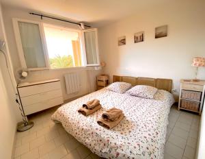 um quarto com uma cama com dois sapatos em cima em 2 bedrooms, 15 min walk to beach, AC, pool & fiber internet in a quiet, private gated domain 5kms to St Tropez em Cogolin mais 35 fotografias