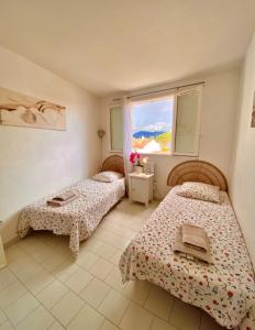 um quarto com duas camas e uma janela em 2 bedrooms, 15 min walk to beach, AC, pool & fiber internet in a quiet, private gated domain 5kms to St Tropez em Cogolin