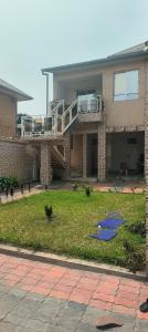 a large house with a balcony and a yard at Affordable Spacious Apartment in Kinshasa, Limete Resit in Kinshasa