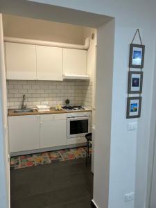 a kitchen with white cabinets and a sink and a stove at Itria Charme Suite in Reggio di Calabria
