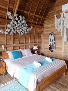 ein Schlafzimmer mit einem großen Bett in einem Holzzimmer in der Unterkunft Beach House on Gamat Bay in Nusa Penida