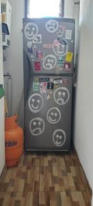 a refrigerator with many stickers on it in a room at Acogedor Departamento in Valparaíso