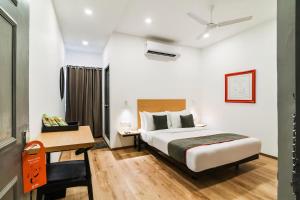 a hotel room with a bed and a desk at RG SUITES Xotel OMR THORAIPAKKAM in Chennai