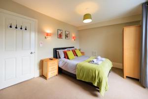 a bedroom with a bed with yellow and orange pillows at two bed Seafront apartment - sea views in Aberystwyth