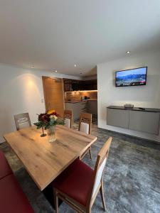 Un comedor con una mesa de madera y una cocina. en Jungmann Apartments, en Ischgl