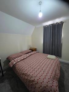 a bedroom with a bed with a red comforter at Stay Near Colchester twn centre4 in Hythe