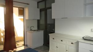 a kitchen with white cabinets and a sink at Studio le Dauphiln du Lagon Bleu - Grand Baie in Grand Baie +1 photo