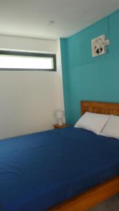 a blue bedroom with a bed and a window at Studio le Dauphiln du Lagon Bleu - Grand Baie in Grand Baie