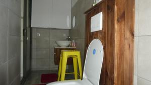a bathroom with a white toilet and a yellow stool at Studio le Dauphiln du Lagon Bleu - Grand Baie in Grand Baie