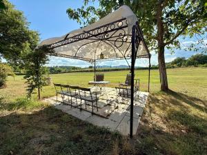 a tent with a table and chairs under a tree at Torre della Soara - Medieval Tower in the Umbrian Countryside in Città di Castello