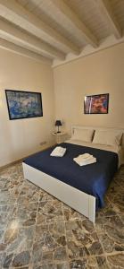 a bedroom with a bed with two towels on it at Le quattro stagioni - The Four Seasons in San Gregorio di Catania