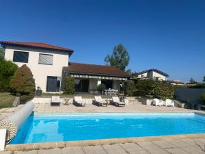 a swimming pool in front of a house at Charmante Maisonnette au calme, proche de Lyon in Dagneux
