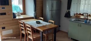 a kitchen with a wooden table and a refrigerator at La cò viéyi - La casa vecchia in Ala di Stura