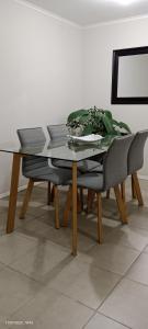 a dining table and a chair with a glass top at Acogedor departamento en Villa Alemana in Villa Alemana