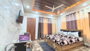 a bedroom with a bed and a tv in it at The Moonlight Stay Kasauli in Kasauli