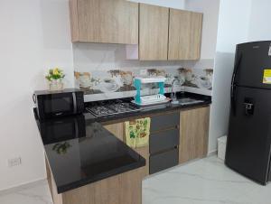 a kitchen with a black refrigerator and a counter top at Apartment in the center of Cali, 2nd Floor in Cali +13 photos