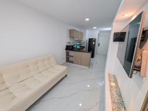 a living room with a white couch and a kitchen at Apartment in the center of Cali, 2nd Floor in Cali