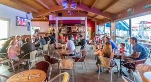 a group of people sitting at tables in a restaurant at mobil home spacieux climatisé sur camping sol a gogo in Saint-Hilaire-de-Riez