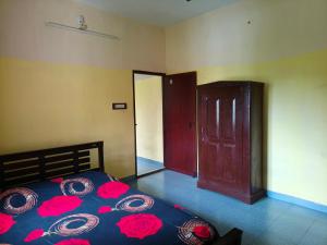 a bedroom with a bed with red roses on it at Mary's Aparts in Cochin