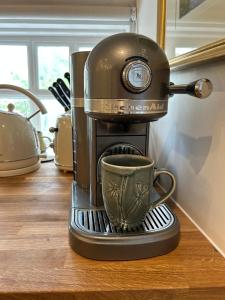 a coffee maker with a cup on a stand at Apartment above Samantha Dadd Art Studio - in the Cotswolds in Tewkesbury +42 photos