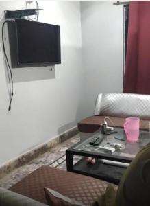 a living room with a couch and a tv on a wall at Roof Top Luxury & Comfort in Sukkur