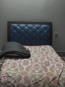 a bed with a headboard and a pillow on it at Roof Top Luxury & Comfort in Sukkur