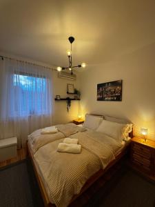 a bedroom with a large bed with two towels on it at Gerecse View Apartman in Dunaszentmiklós