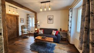 a living room with a couch and a table at chalet cosy, jacuzzi privé, calme, idéal moto rando vélo in Bellecombe