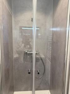 a shower with a glass door with a person taking a picture at IL Mulino House D in Ons Belang