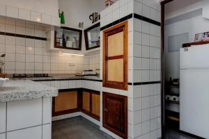 cocina con paredes de azulejos blancos y nevera en Casa Vista Caldera, en Tijarafe
