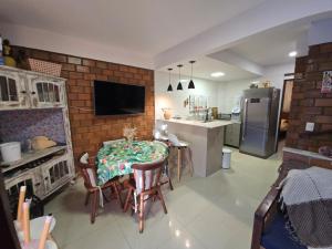 eine Küche und ein Esszimmer mit Tisch und Stühlen in der Unterkunft Casa Equipada e Confortável p seu Lazer em Gravatá in Gravatá