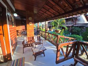 eine Veranda mit 2 Stühlen und einem Tisch auf einem Haus in der Unterkunft Casa Equipada e Confortável p seu Lazer em Gravatá in Gravatá