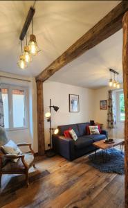a living room with a couch and a table at chalet cosy, jacuzzi privé, calme, idéal moto rando vélo in Bellecombe
