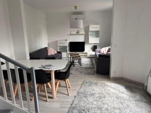 a living room with a table and chairs and a couch at Maison Mont Valérien Spacious Family and Business Stay with AC and Parking, near Paris La Défense in Nanterre