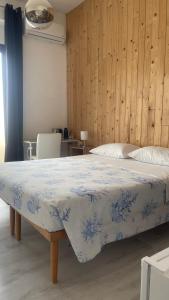 a bedroom with a bed with a blue and white blanket at Camera in centro storico in Olbia